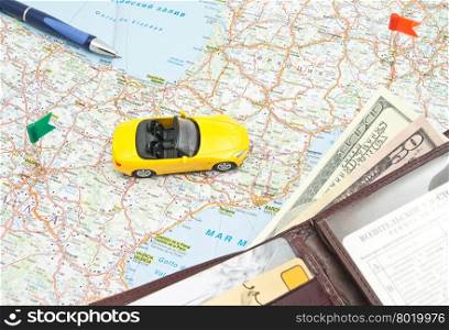 yellow car, pen and leather wallet on the map of Europe