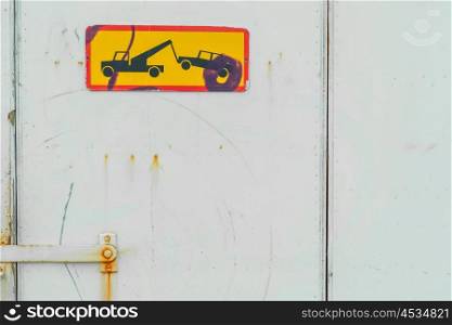 Yellow car removal sign on a grungy port