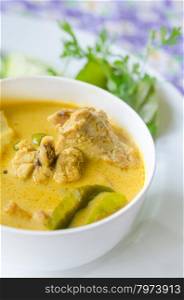 yellow chicken curry. yellow chicken curry in bowl served with fresh vegetable