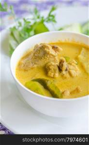 yellow chicken curry. yellow chicken curry in bowl served with fresh vegetable