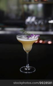 Yellow Cocktail glass with ice at a bar counter