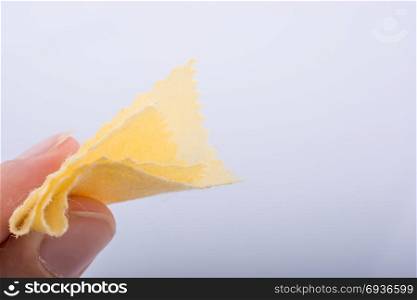 Yellow color mini handkerchief in hand on white background