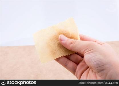 Yellow color mini handkerchief in hand on white background