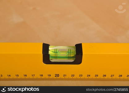 yellow construction level on a brown wooden background