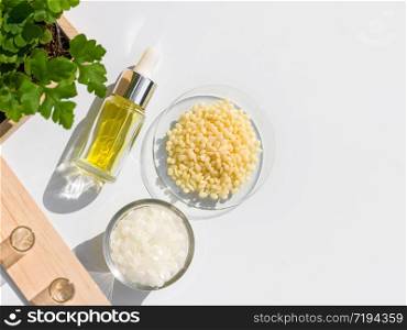 Yellow cosmetic color (oil), Microcrystalline wax and Candelilla Wax. Chemicals for beauty care arranged in natural form in a white background. (Top View)