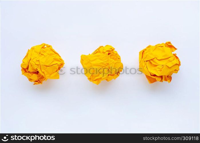 Yellow crumpled paper ball isolated on white background.