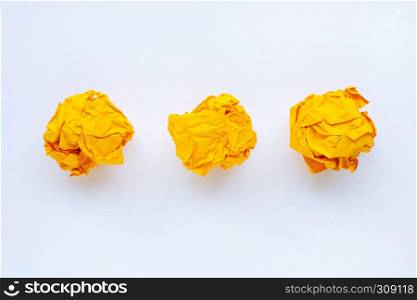 Yellow crumpled paper ball isolated on white background.