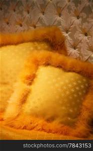 yellow cushions with fluff on a bed