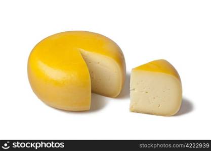 Yellow Dutch Gouda cheese with a piece on white background