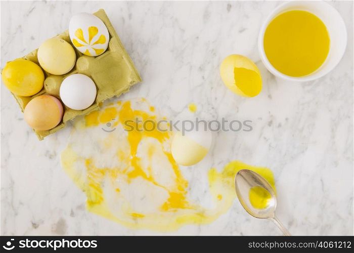 yellow easter eggs container near spoon dye liquid