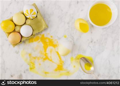 yellow easter eggs container near spoon dye liquid