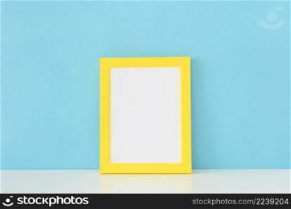 yellow empty frame front blue wall