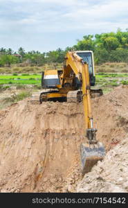 Yellow excavator machine working earth moving works at construction site