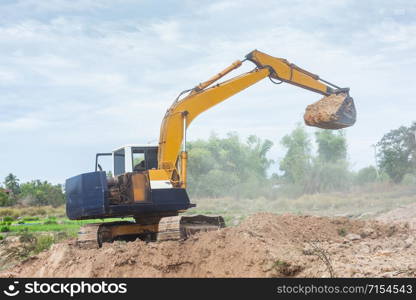 Yellow excavator machine working earth moving works at construction site