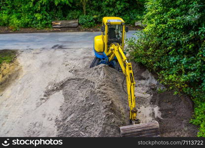 yellow Excavator with a heap of sand, earthmoving industry, digger machine for moving sand