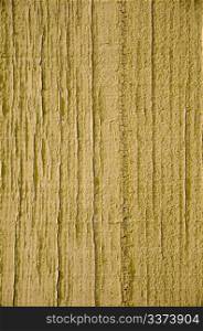 Yellow flaky paint on a wood background.