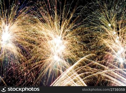 yellow flashes of a festive firework in the night sky