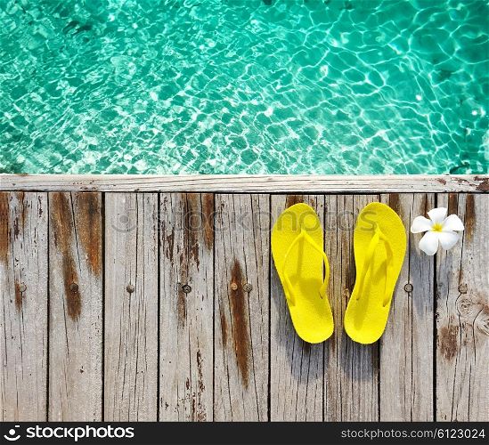 Yellow flip-flops on beach jetty