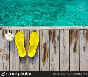 Yellow flip-flops on beach jetty