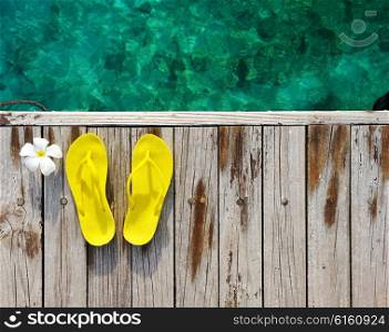 Yellow flip-flops on beach jetty