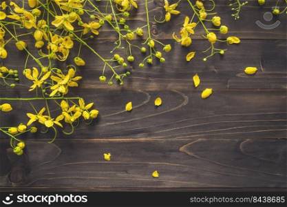 Yellow flower on wooden background with space with vintage toned.
