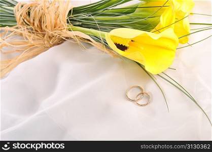 yellow flowers and wedding rings