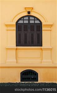 Yellow French Colonial building facade and artisan window frame of Udon Thani city museum, Thailand
