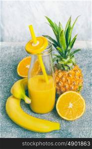 Yellow fruits smoothie in bottle with drinking Straw and fresh ingredients: banana, orange and pineapple, front view, copy space