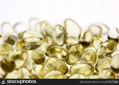Yellow gel capsules with medicine in them.. Vitamin Capsules