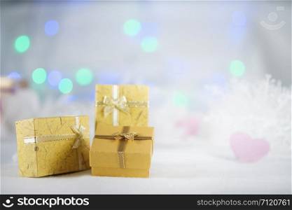 Yellow gift boxes on the white fur , bokeh background, with copy space for season greeting, Merry Christmas or Happy New Year.AF point selection, blurred.