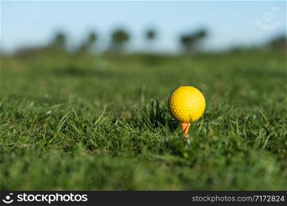 yellow golf ball on the ground at the driving range