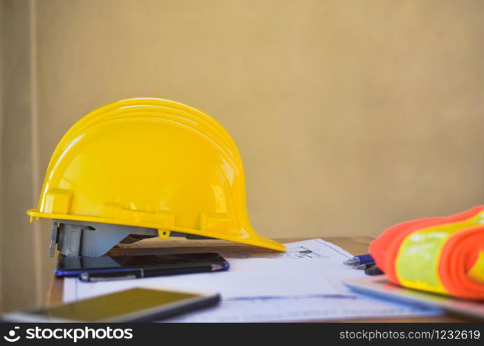 Yellow hard hat for Engineer Foreman Supervisor at construction site is on office desk