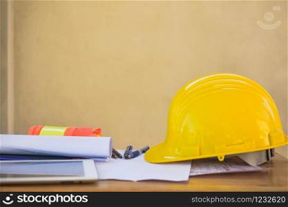 Yellow hard hat for Engineer Foreman Supervisor at construction site is on office desk