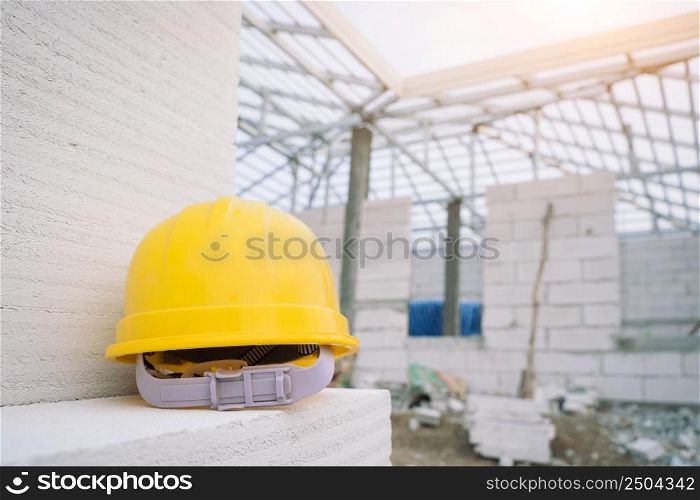 Yellow hard hat on at construction site,Hard hat and glove construction concepts.