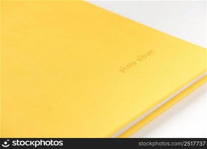 Yellow hardcover photo album on white background. Close-up. book album on a white background