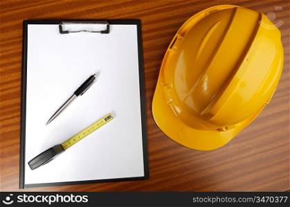 yellow helmet and notepad on a table