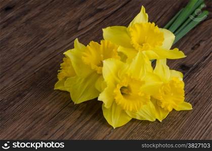 Yellow jonquil flowers on wooden background.