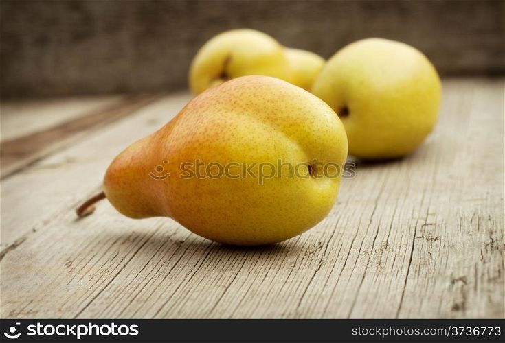 Yellow juicy ripe pears on a wooden background
