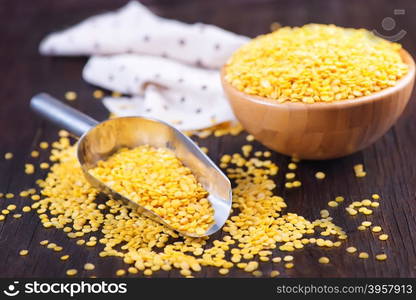 yellow lentil in bowl and on a table