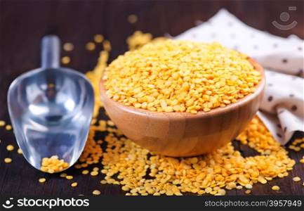yellow lentil in bowl and on a table