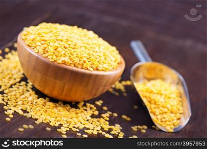 yellow lentil in bowl and on a table