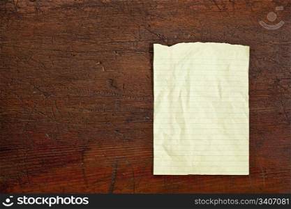 yellow lined notepad paper sheet against dark grunge wood table