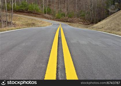 Yellow lines and a curve in a new road.