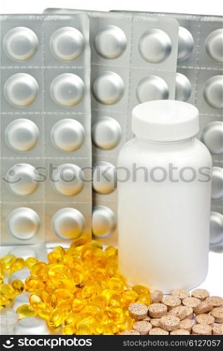 Yellow liquid capsules and silvery plates of medicines near a bottle