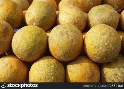 yellow melon fruits market stacked rows sunny day