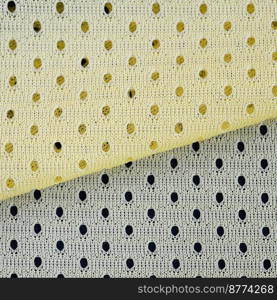 Yellow mesh sport wear fabric texti≤pattern background. Yellow color football jersey clothing fabric texture sports wear. Breathab≤porous poriferous material air ventilation with small ho≤s. Yellow mesh sport wear fabric texti≤background pattern