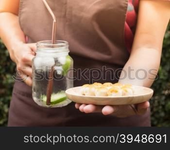 Yellow mini cakes and lime Infused detox water, stock photo