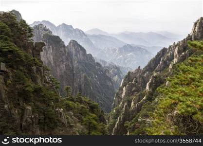 Yellow mountain valley in China during daylight with mountain range and sky in background