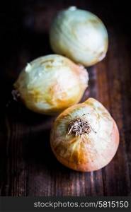 Yellow onions on wooden background