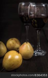 yellow pear with red wine on wooden table